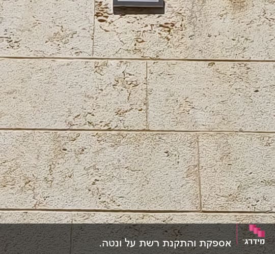 תריס אוורור מתכתי המותקן על קיר אבן חיצוני
